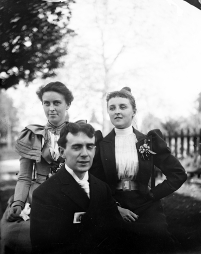 a man and 2 women sitting together outside