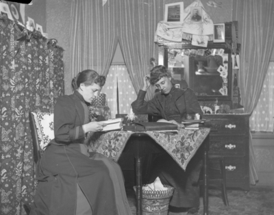 2 women sitting at a table reading