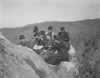 6 women and a man sitting on rocks (appear to be some of the same people as from item #30)