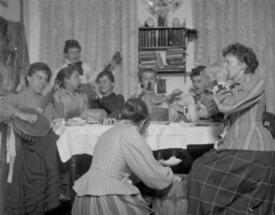 a group of women sitting around a table playing music