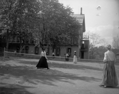 women playing tennis, possibly behind Patterson Hall on land that is now occupied by Blazer Hall
