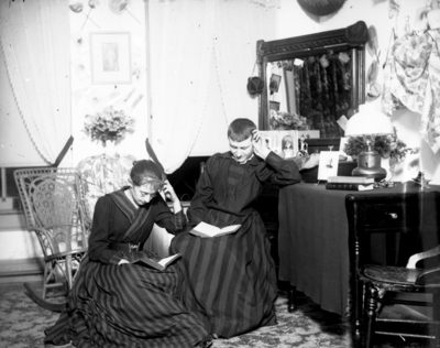 a woman and a man dressed as a woman sitting and reading