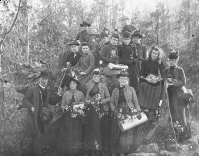 a large group portrait taken in a wooded area