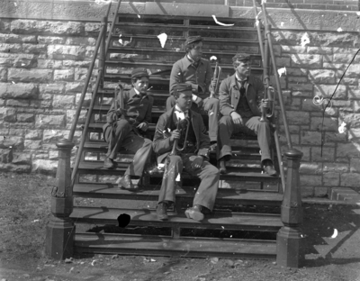 4 men on steps holding bugles