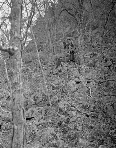 women climbing the side of a very steep hill