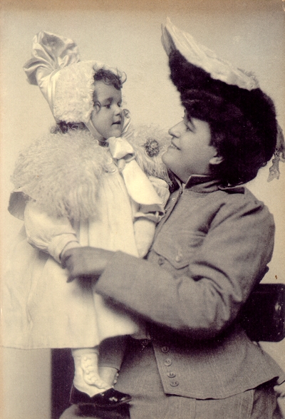 Woman in dress suit holding dressed up child
