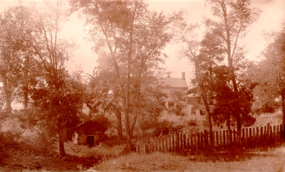 House surrounded by trees and old fence