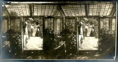 Greenhouse with door leading to garden; Three people looking at camera