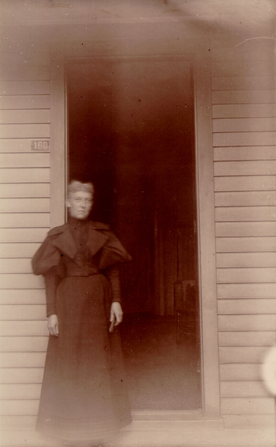 Woman standing in doorway labeled #160