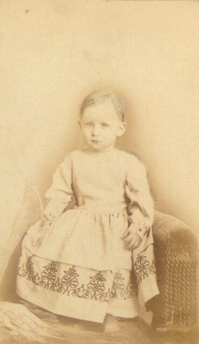 Baby in white dress with hair partially drawn in
