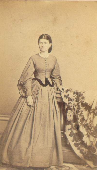 Young woman with full length dress standing near rail