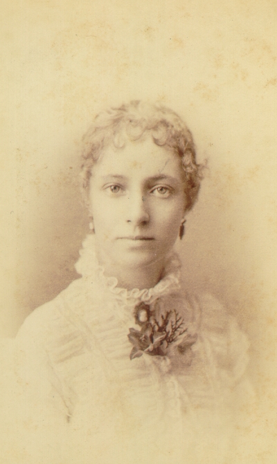 Young woman in white ruffled blouse and flower pin on chest