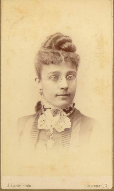 Young woman wearing dark dress and glasses; Western Female Seminary