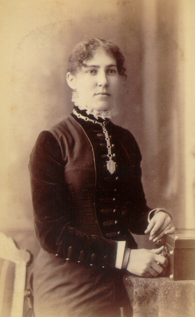 Young woman wearing black dress and crest necklace; Western Female Seminary