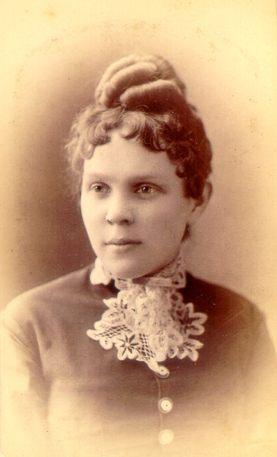 Young woman wearing dark dress with lace collar; Hair done up in a bun; Western Female Seminary