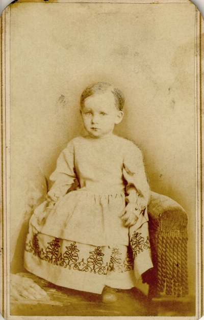 Toddler girl in nice white dress with black pattern at bottom