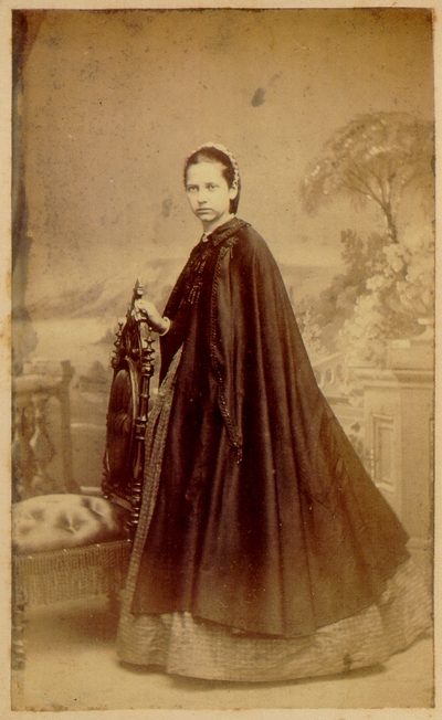 Young woman wearing dress and long cape