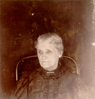 Elderly woman in black blouse sitting in a chair