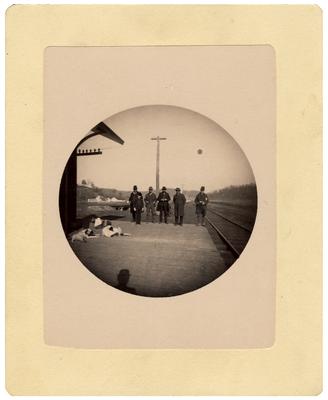 Five unidentified men standing on platform by railroad tracks; removed from pg. 15 of album
