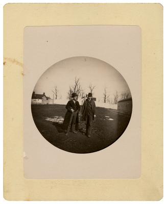 Two unidentified men standing in field; removed from pg. 22 of album
