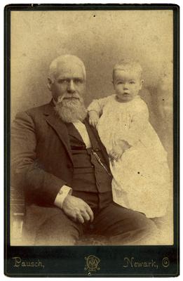 Unidentified man holding infant; found loose in back cover of album; handwritten on back in ink                              Mayhew Wing Shields / Born July 1st 1887