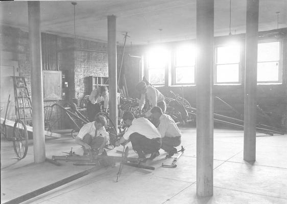 Students in shop class, repairing machinery