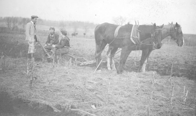 A man and two women farmers with horses and plow