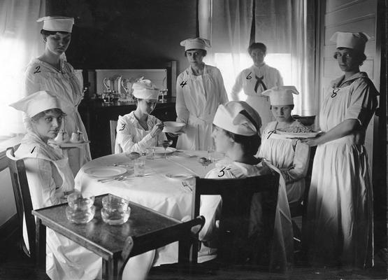 Women students at a table in the Home Economics Practice House