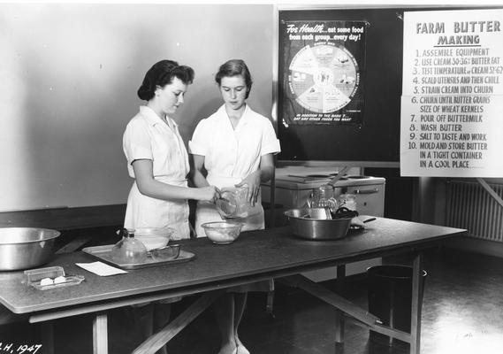 Two young women demonstrating how to make butter, 1947