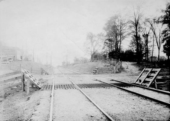 African American woman standing at base of hill near railroad tracks