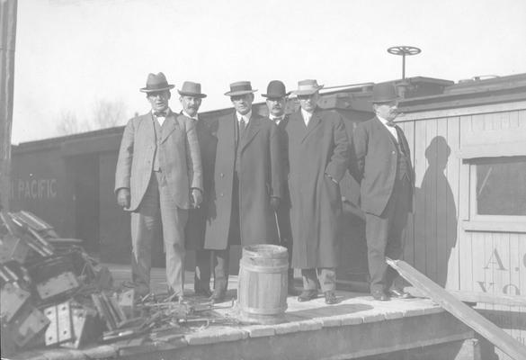 Group of men standing on platform near train