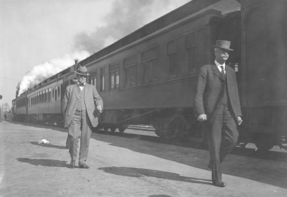 Men walking beside train