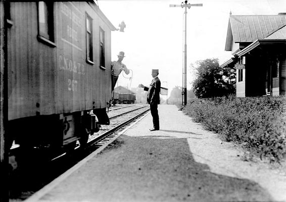 Man in caboose picking up train orders 
