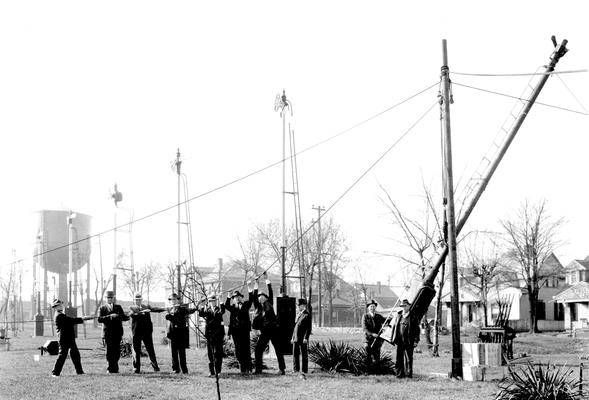 Men raising signal pole