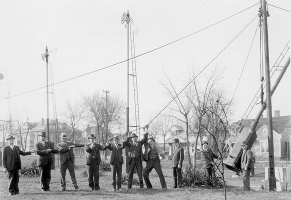 Men raising signal pole
