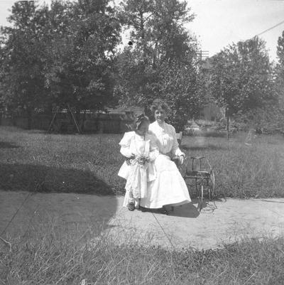 Woman and young girl with doll sitting outside