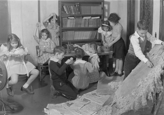 Students working with animal hides, spinning with wool and sewing