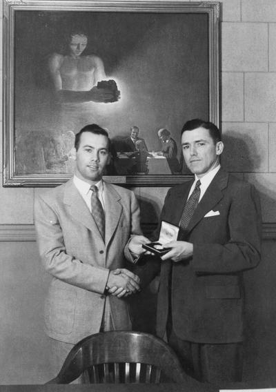 Man receiving an award from another man