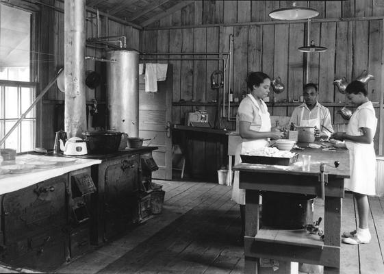 Two African-American women and a man preparing food for the surveying class