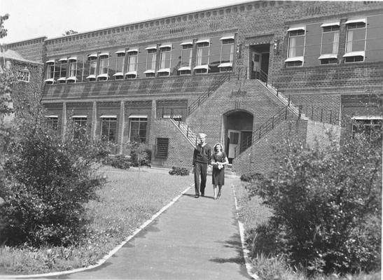 Man in naval uniform and a woman in front of an engineering building