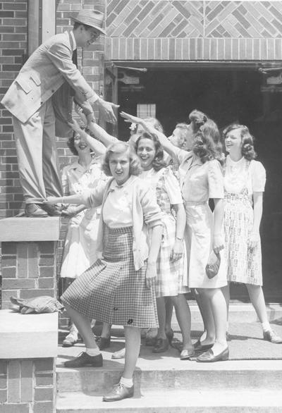 Young women gathered around a man