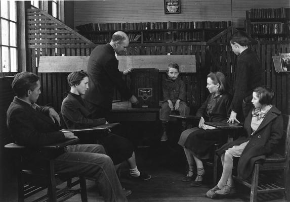 Students and teacher observing a radio