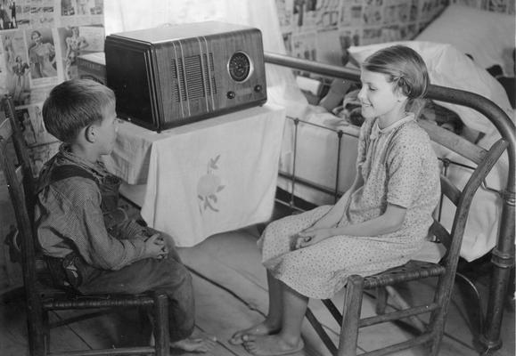 Young woman and a young man sitting and listening to the radio