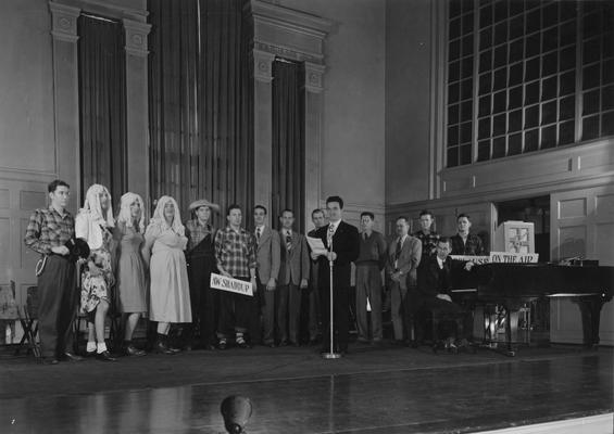 Radio station broadcasting from Memorial Hall, including three men in dresses and mop wigs