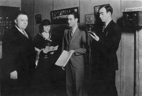 Unidentified men and unidentifed woman reading to the radio listeners