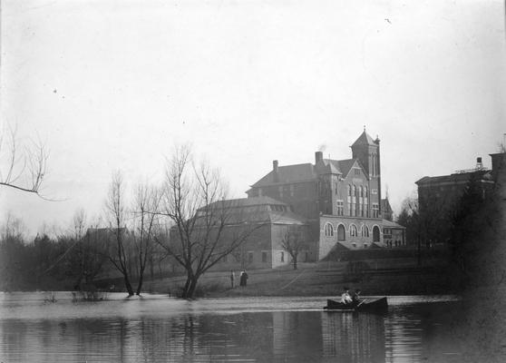 Scene of the lake and man and woman in canoe and the campus, circa 1903 - 1919