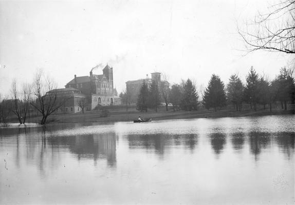 Scene of the lake and man and woman in canoe and the campus, circa 1903 - 1919