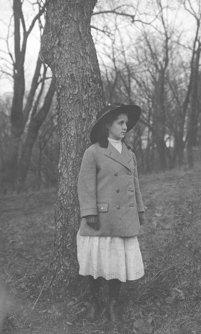 Young woman standing by a tree