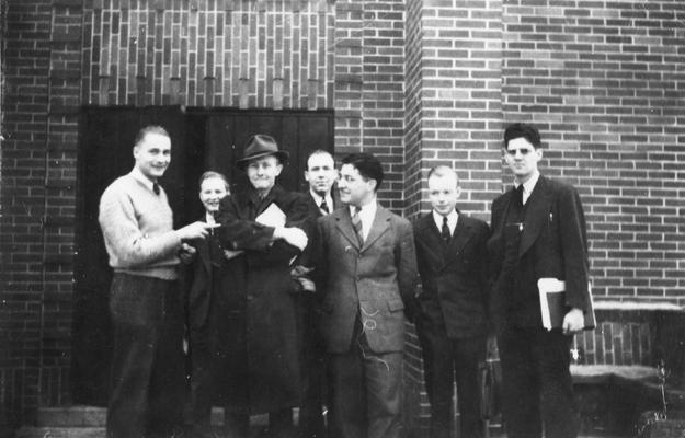 Men standing on steps in front of Law Building, Lafferty Hall