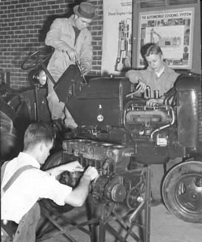 James Ison, Porter Read and Gerald Schaffer working on tractor engines in Agricultural Engineering Laboratory, page 65, 1941 
